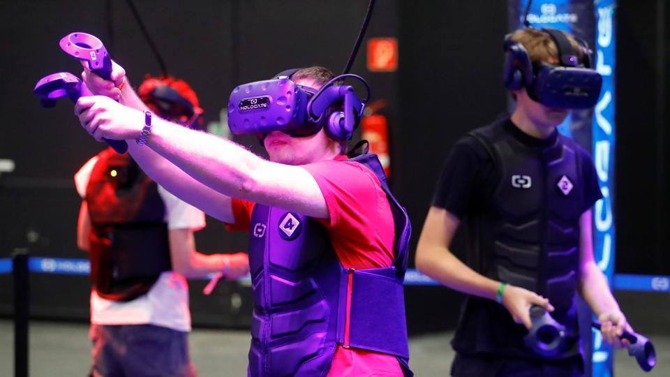 A gamer wears augmented reality goggles to play a shooting game during Europe