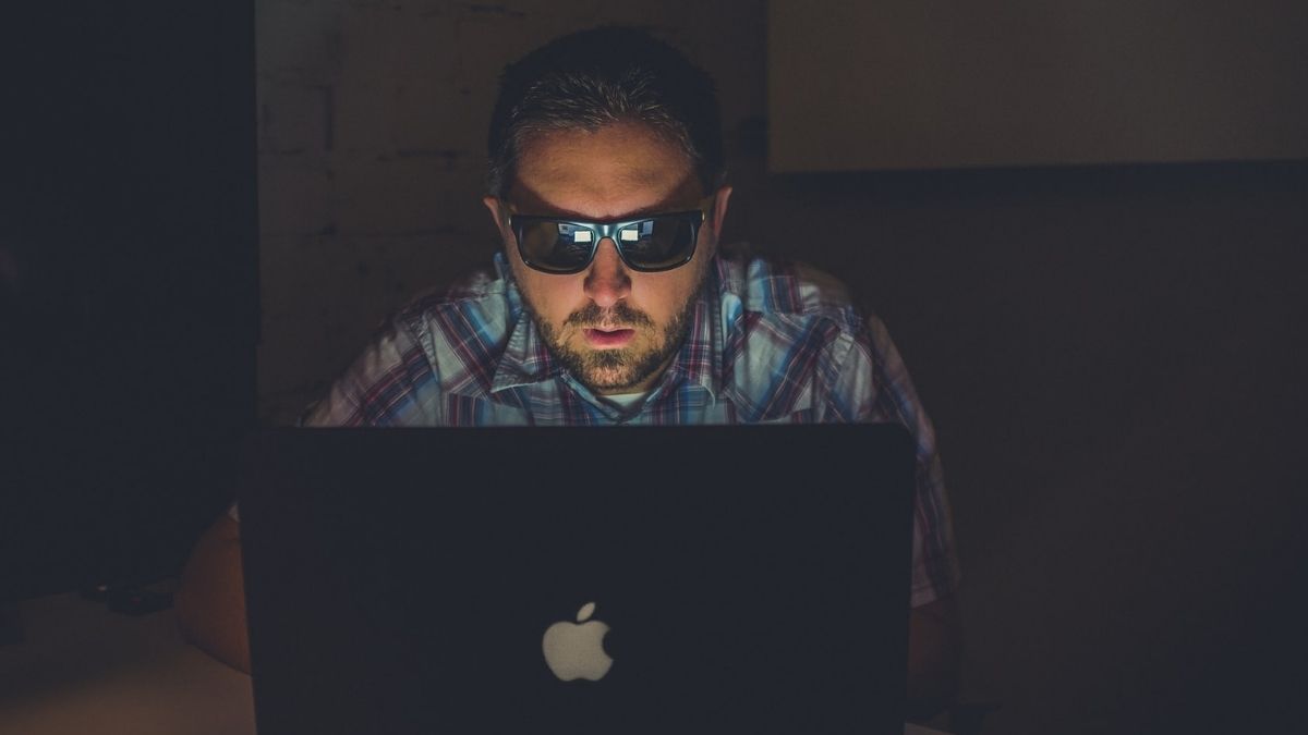 Man With Black Goggles Using Macbook