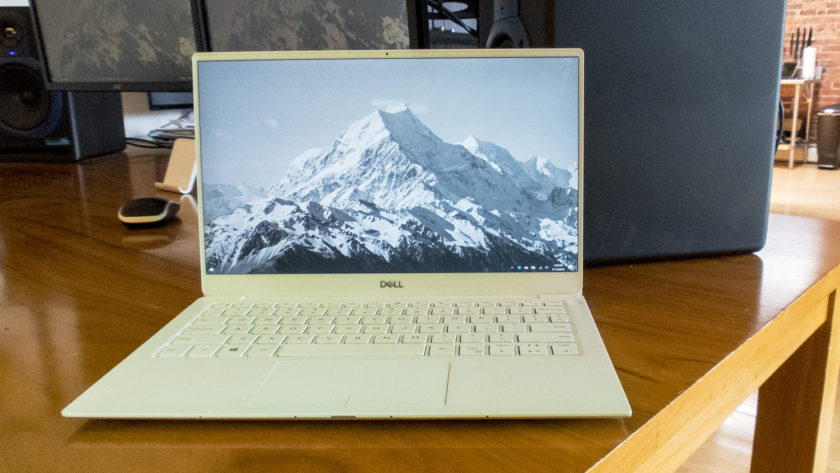 Dell XPS 13 2019 издание сидит на столе с горным пейзажем в качестве фона.